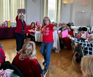 A woman in red shirt and jeans dancing.